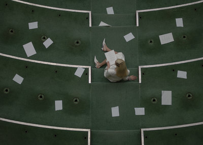 a woman sitting on the ground in front of a green wall