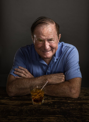 a man sitting at a table with a drink in front of him