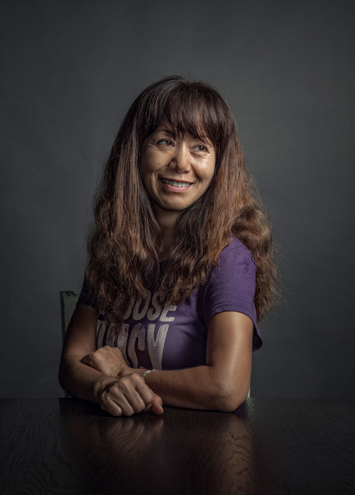 a woman sitting at a table with her arms crossed