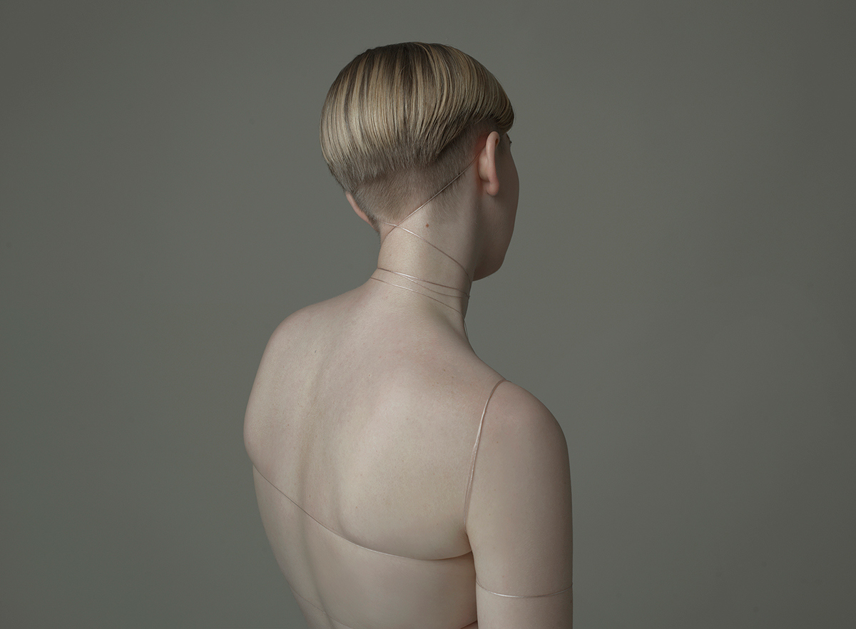 a nude woman with no shirt on looking back