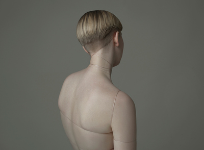 a nude woman with no shirt on looking back