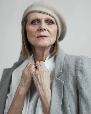 an older woman wearing a hat and a jacket