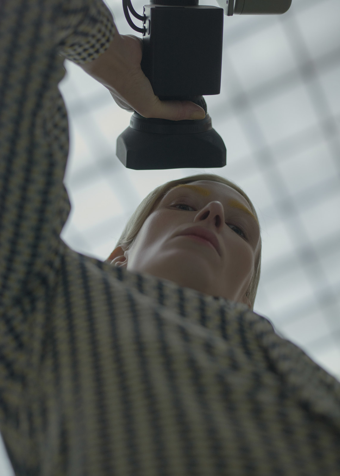 a woman holding a camera up to her face