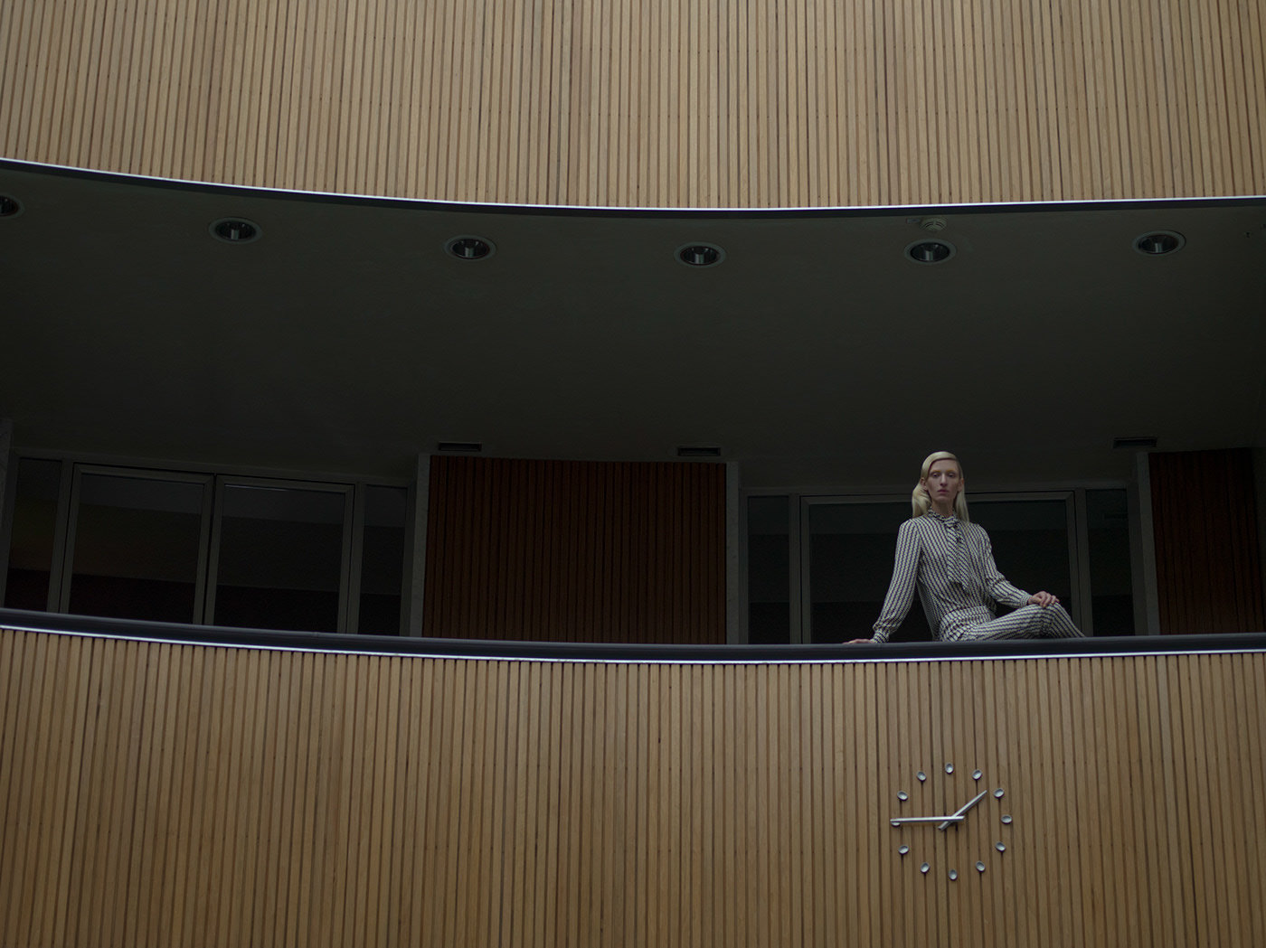 a woman sitting on a ledge in front of a building