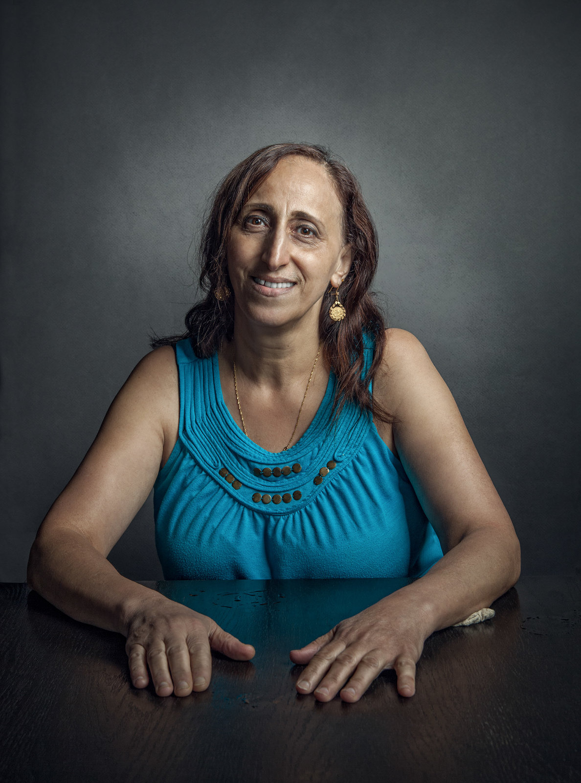 a woman sitting at a table smiling for the camera