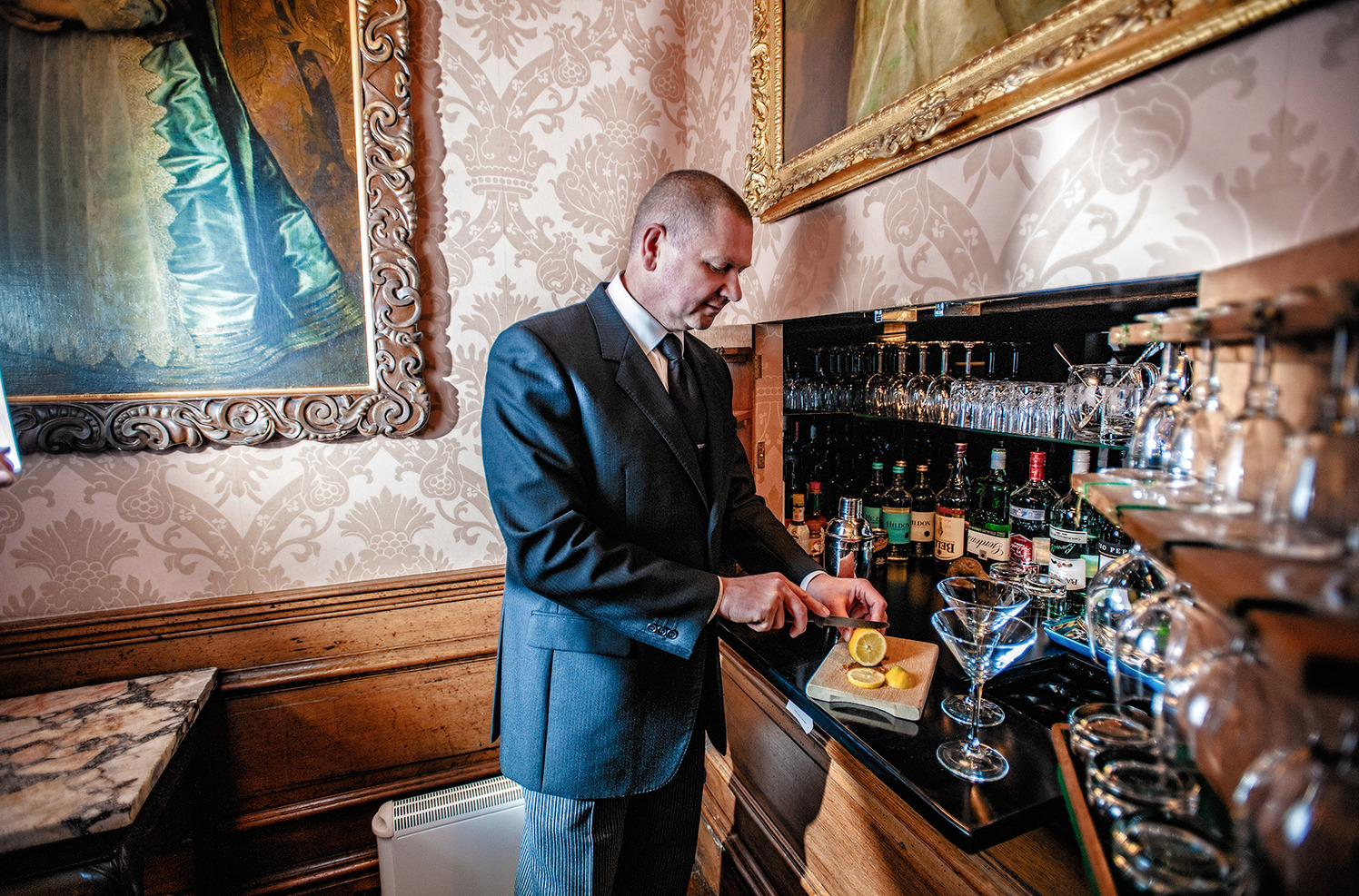 a man in a suit and tie standing at a bar