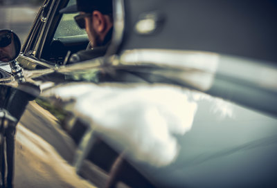 a man sitting in a car looking out the window