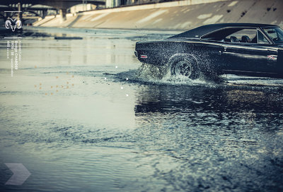 a black car driving through a flooded street