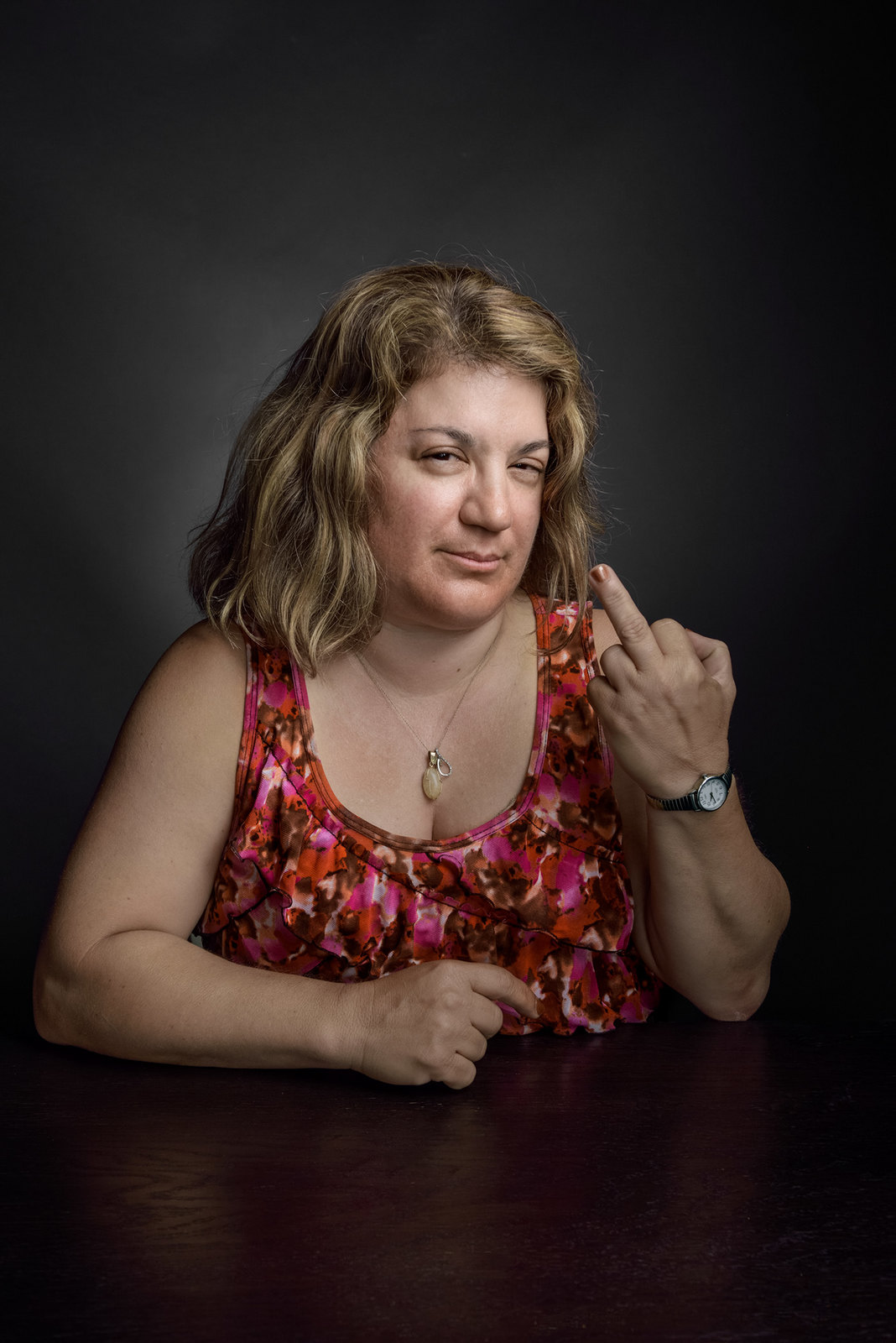 a woman sitting at a table with her hand on her chin