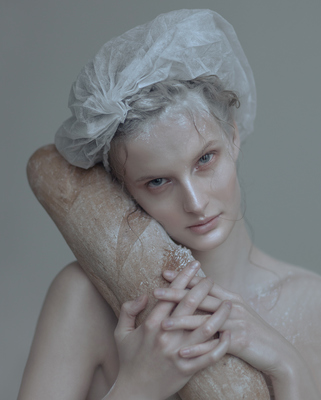 a woman with a large piece of bread in her hand