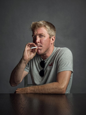 a man sitting at a table smoking a cigarette