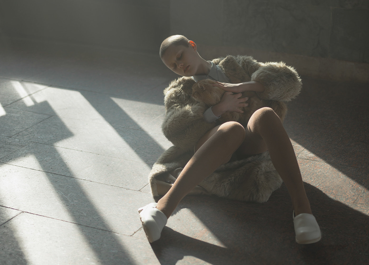 a woman sitting on the ground holding a teddy bear