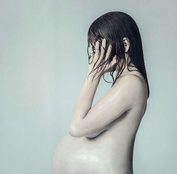 a pregnant woman with her hands on her head