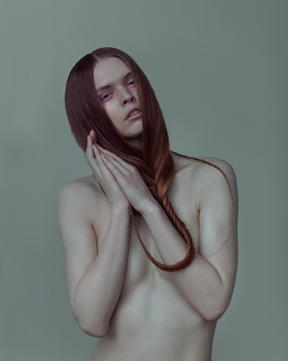 a naked woman with long red hair covering her face