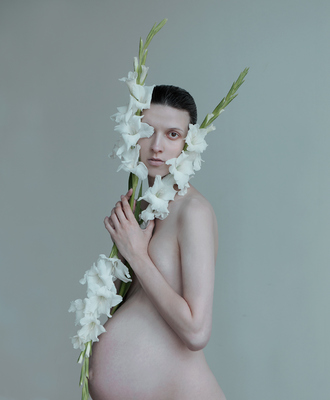 a pregnant woman with flowers around her neck