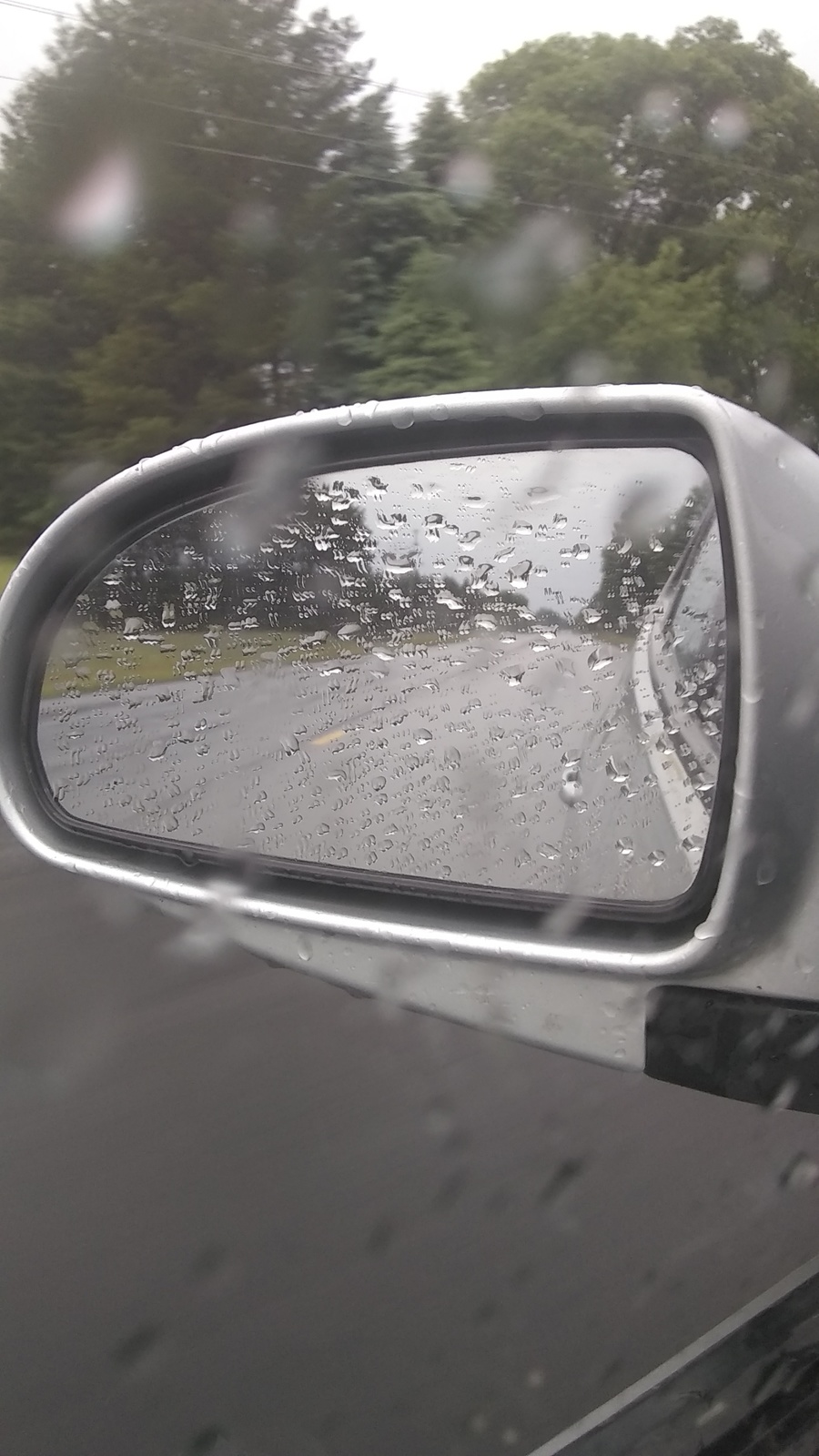 a car's side mirror with rain drops on it