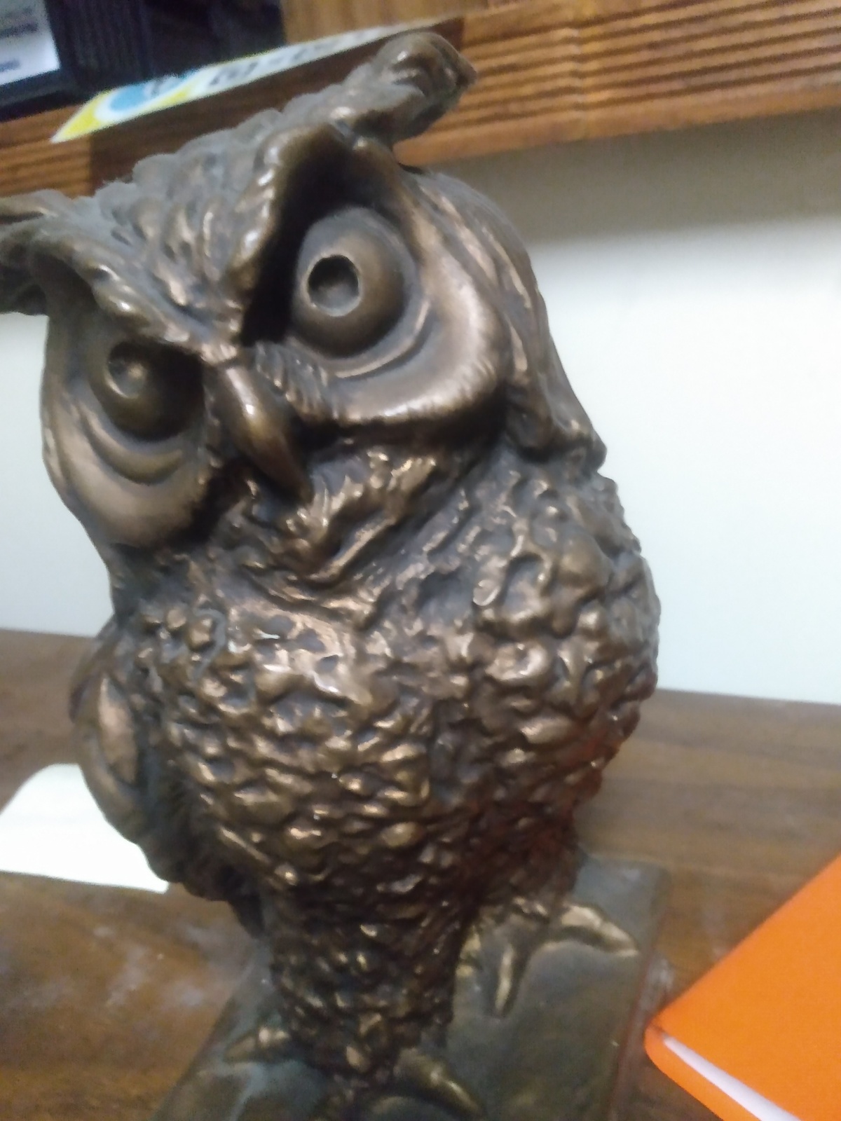 an owl statue sitting on top of a wooden table