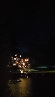 fireworks are lit up in the night sky over a body of water