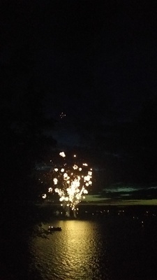 a fireworks is lit up in the night sky over a body of water