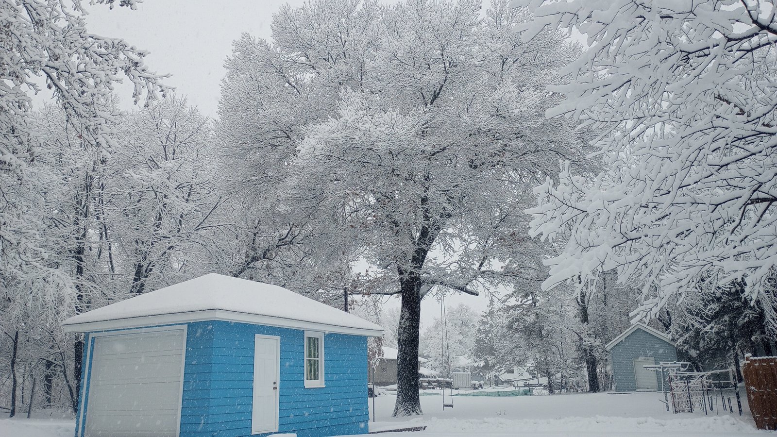 a small blue and white building in the snow