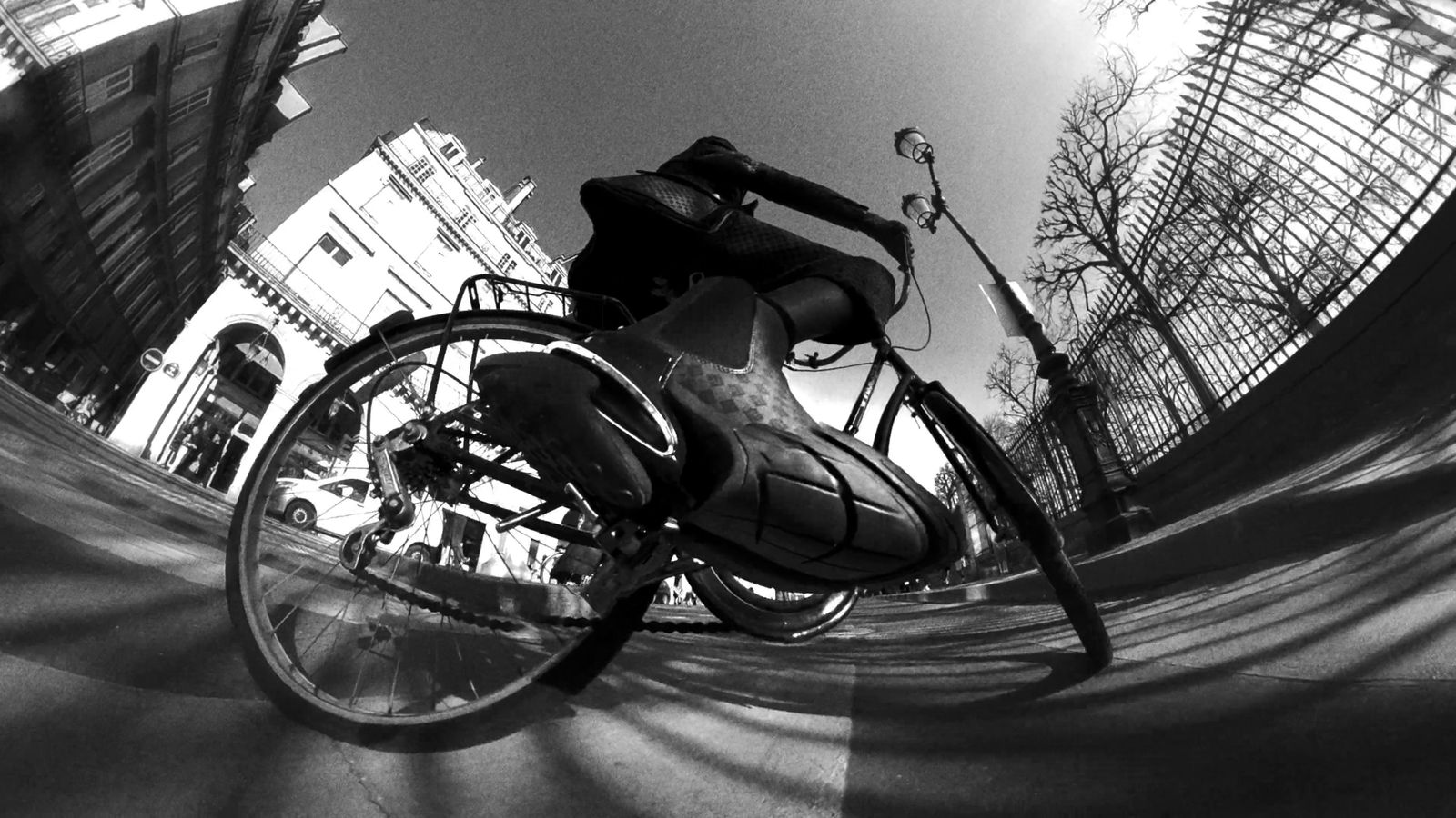 a man riding a bike down a street next to tall buildings