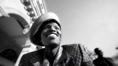 a black and white photo of a woman wearing a hat