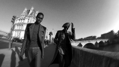 a couple of people walking across a bridge