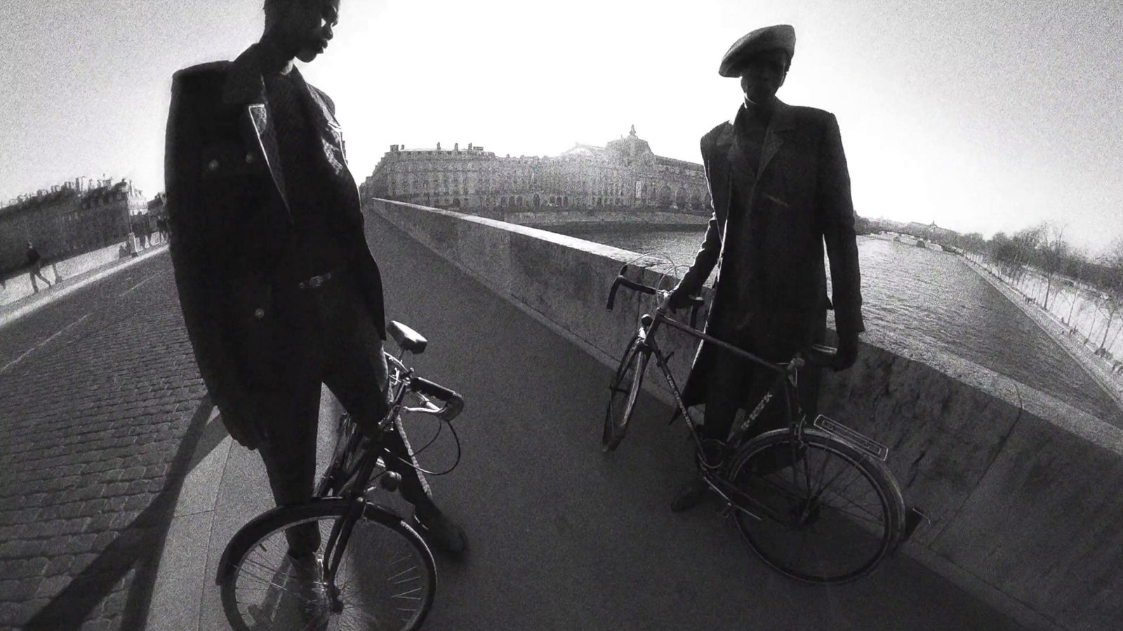 a man and a woman riding bikes on a bridge