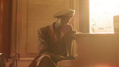 a man sitting on a chair in front of a window