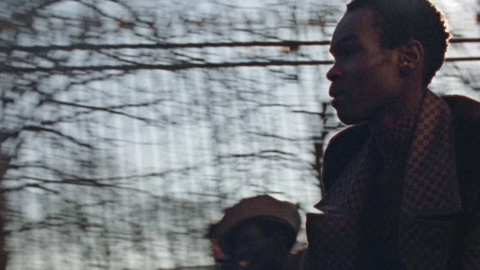 a man standing in front of a window holding a cell phone