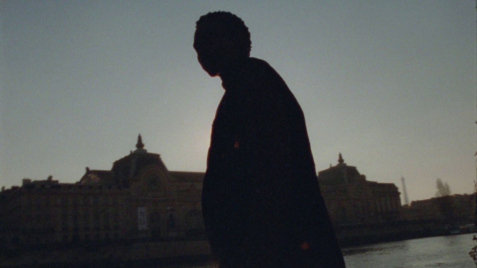 a man standing in front of a body of water