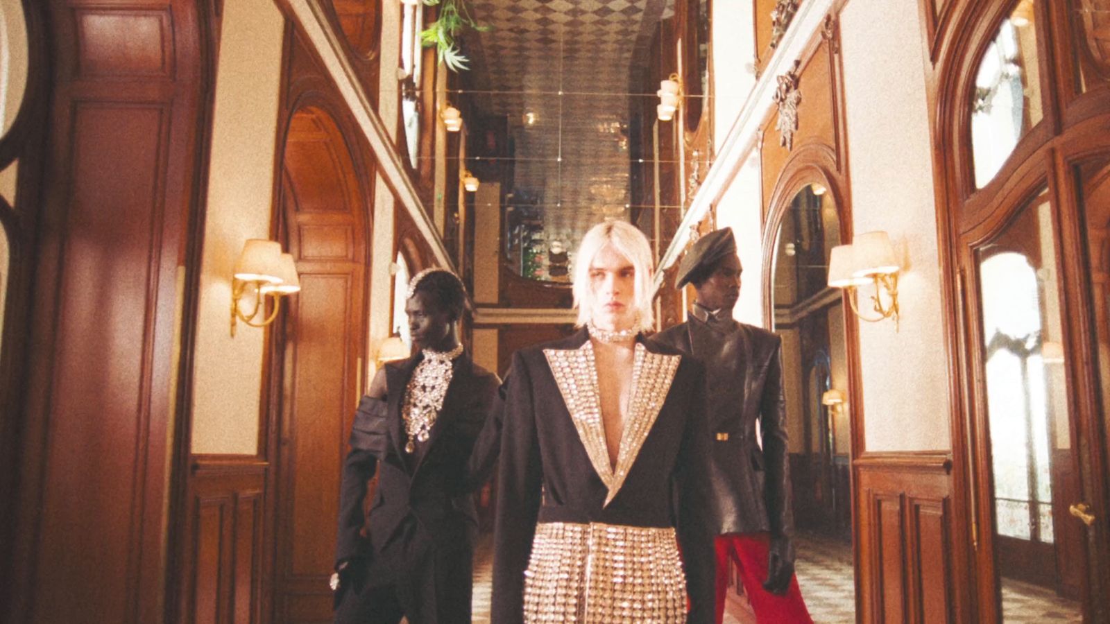 a woman standing in a hallway between two men