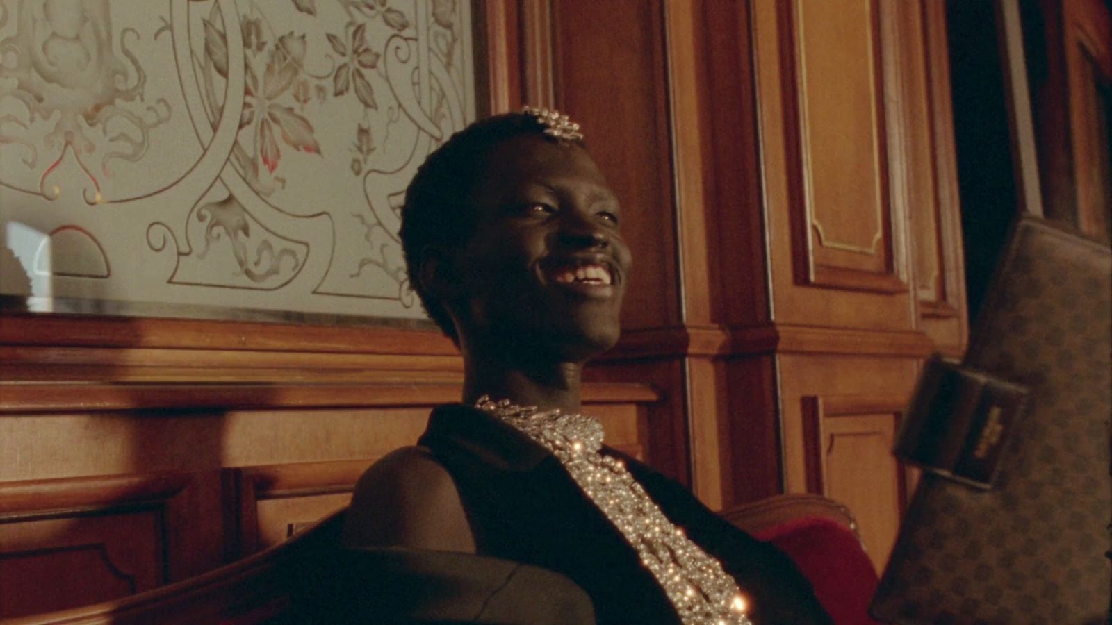 a woman sitting in a chair wearing a tiara