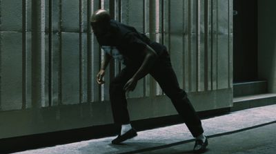 a man walking down a street next to a tall building