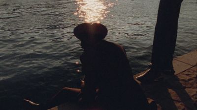 a person sitting on a dock near the water