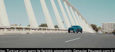 a blue car driving across a bridge over water