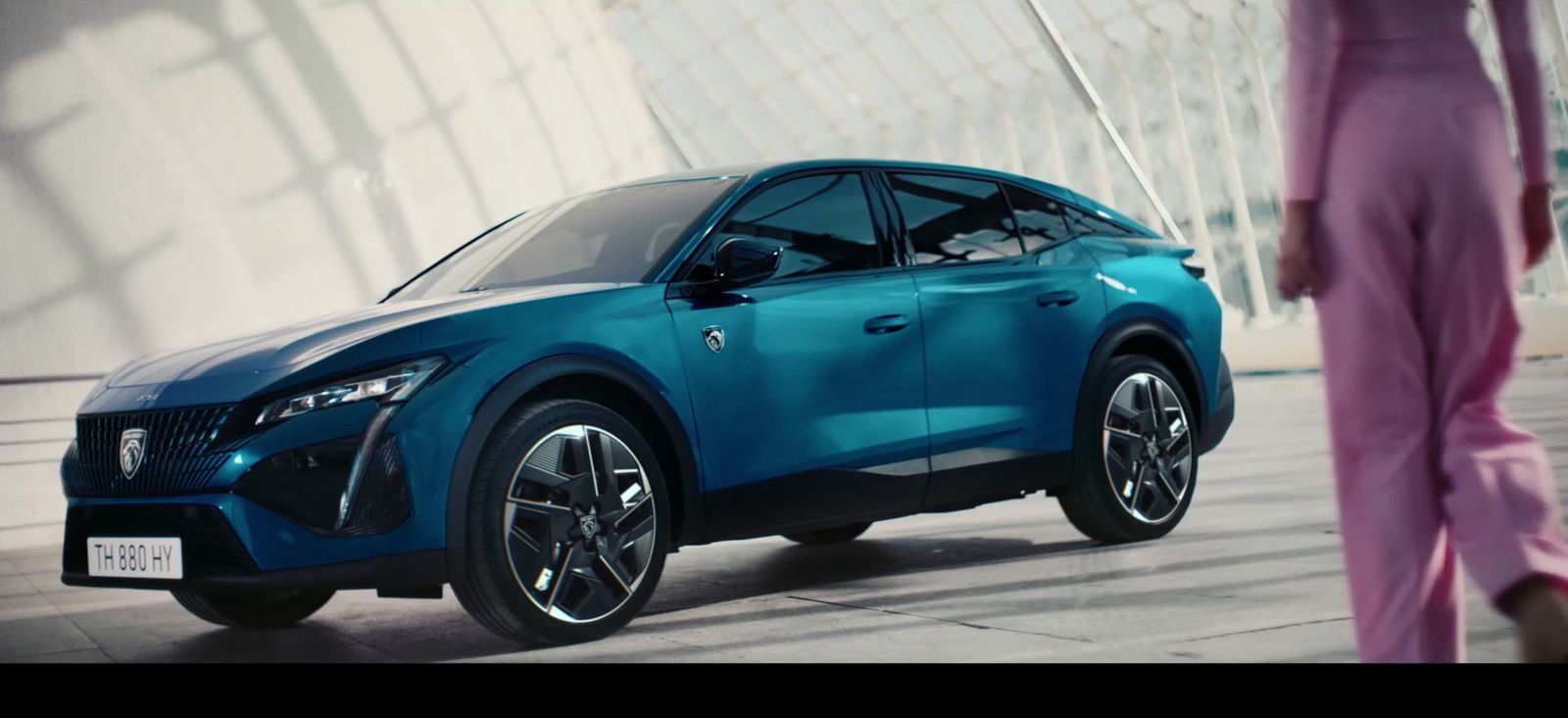 a woman walking past a blue nissan suv