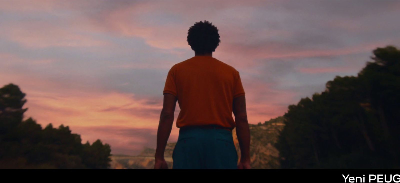 a man standing in front of a sunset