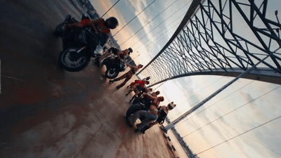 a group of people standing next to a motorcycle