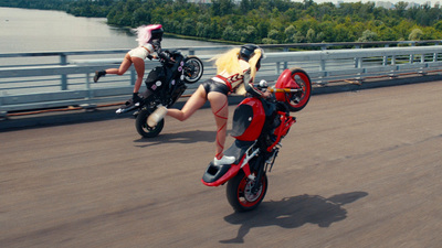 a couple of women riding motorcycles down a road