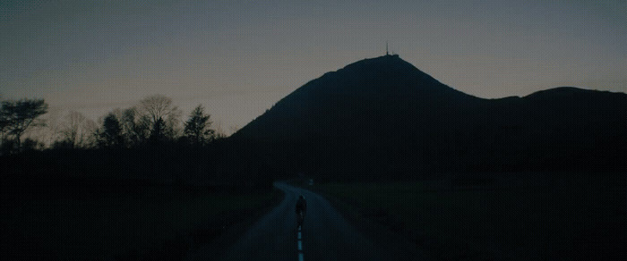 a person standing on the side of a road in the dark