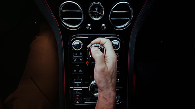 a man is pressing a button on a car dashboard