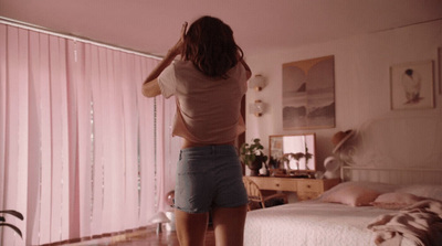 a woman standing on a bed in a bedroom