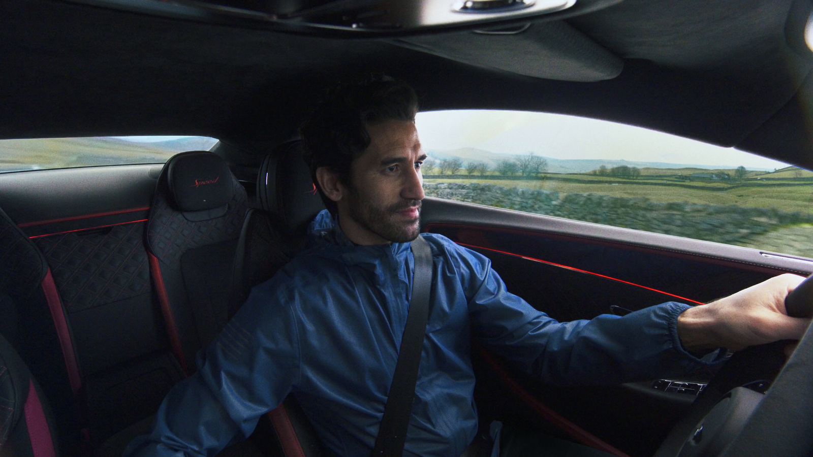 a man sitting in a car with a steering wheel