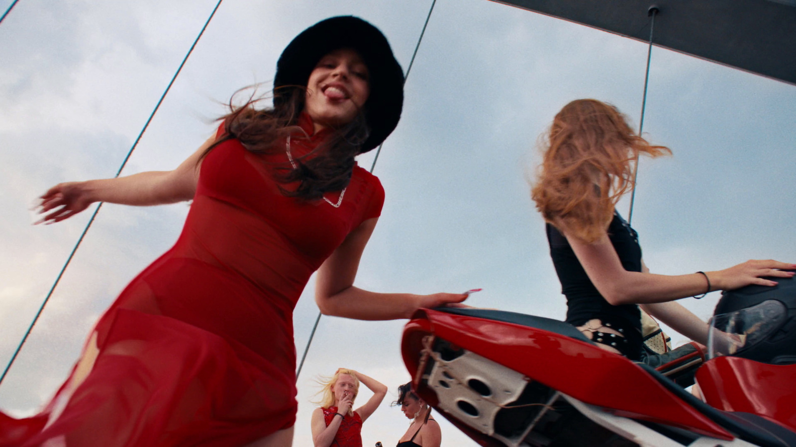 a woman in a red dress riding a red motorcycle