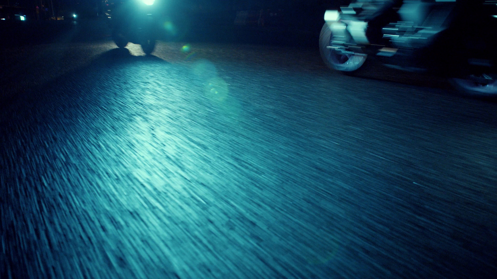 a person riding a motorcycle down a street at night