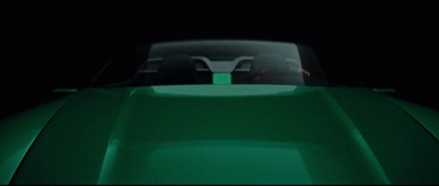 a close up of a green car in the dark