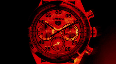 a close up of a red watch on a black background