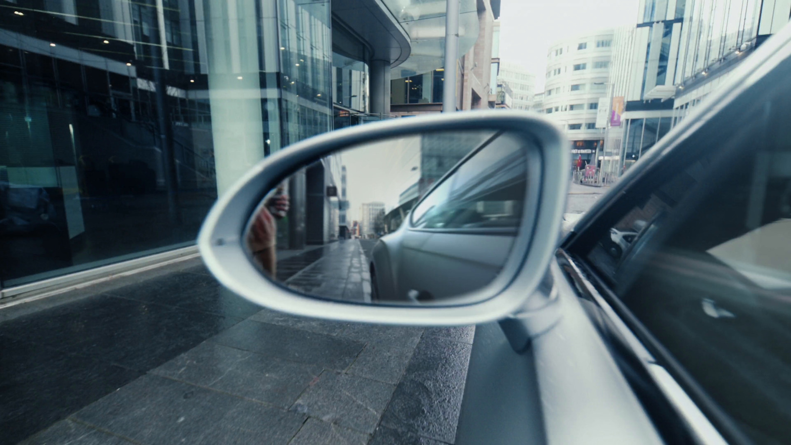 a side view mirror of a car on a city street