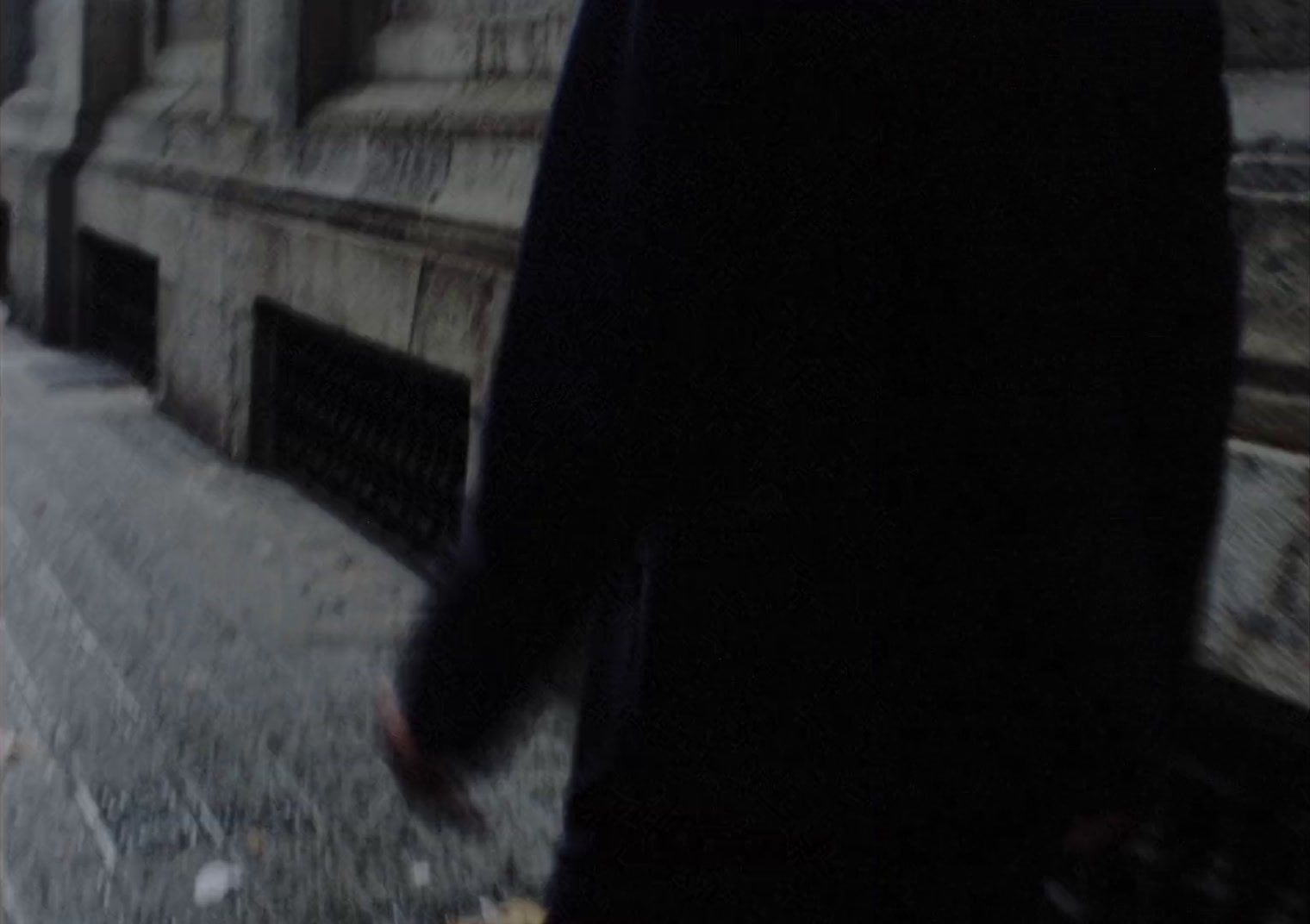 a man walking down a sidewalk next to a building